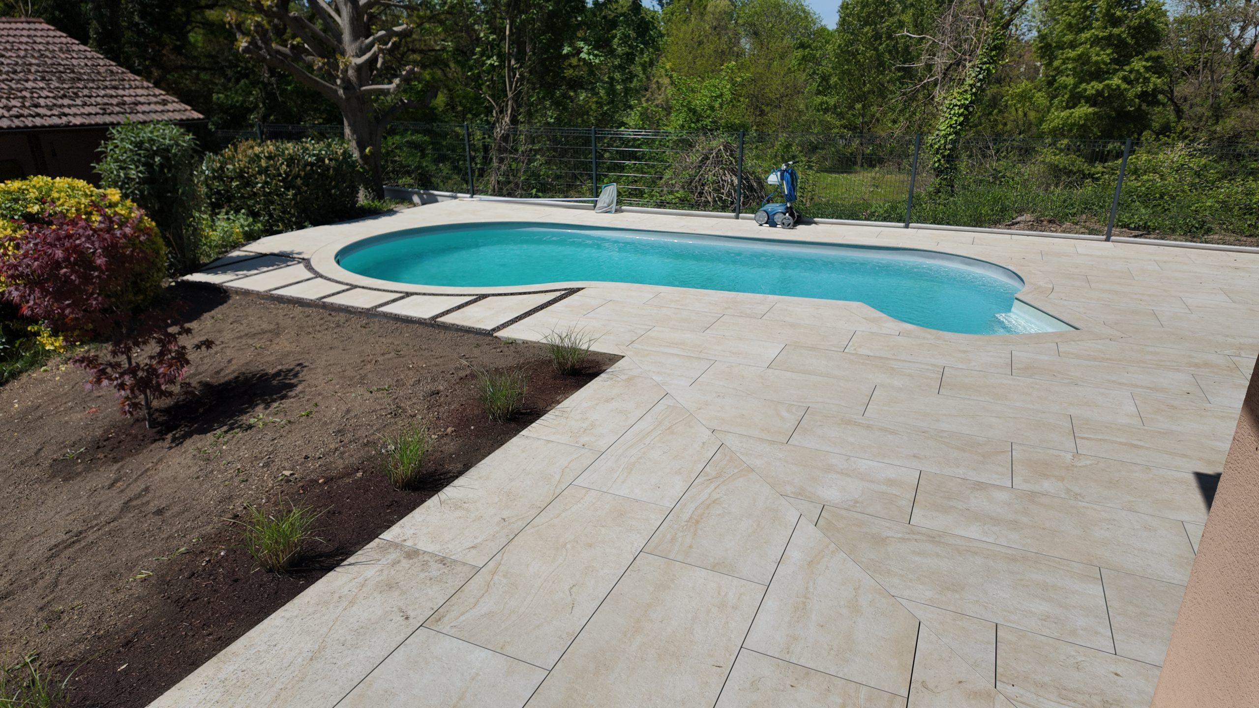 Terrasse en grès cérame aspect travertin et piscine réalisées à Saint-Louis par L'Art Eau Jardin