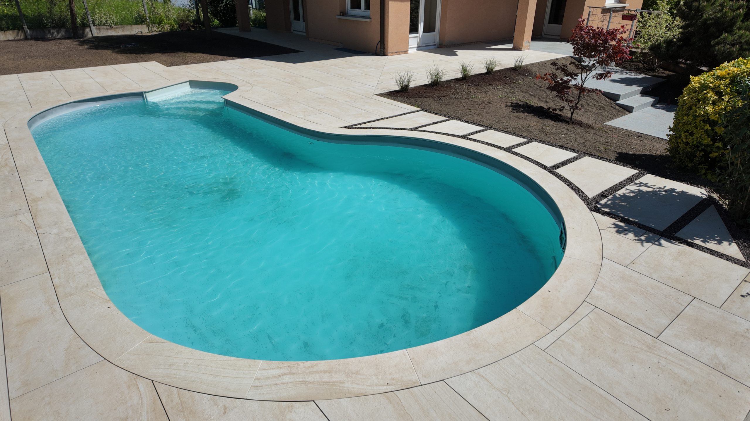 Piscine et terrasse en grès cérame à Saint-Louis, aménagement paysager par L'Art Eau Jardin
